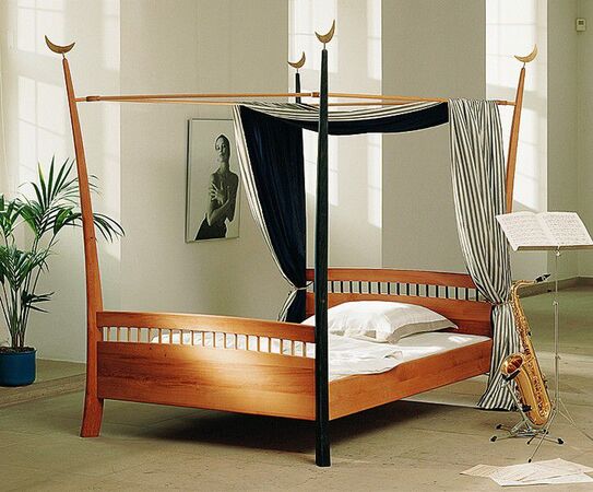 Modernes Himmelbett aus Holz mit dekorativem Baldachin in stilvoll eingerichteter Wohnung.